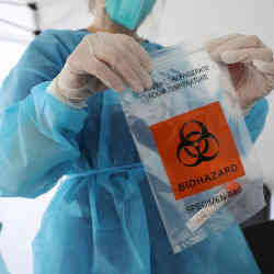 医疗专业人员将冠状病毒检测材料密封在标本袋中。