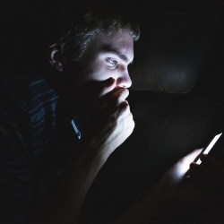 在黑暗中看手机的人
