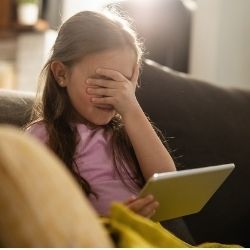 小女孩使用平板电脑的照片遮住了她的眼睛。