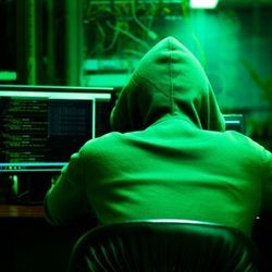 蒙面勒索软件罪犯在电脑上进行数据攻击。