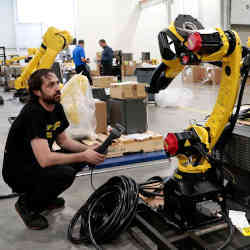 一名技术员准备了一个制造机器人，用于在MI奥本丘陵山的FANUC美国设施中运送给客户。