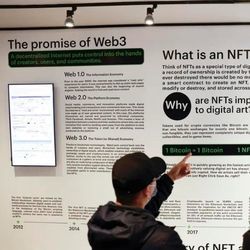 与会者在会议上阅读Web3和NFTs发布的信息
