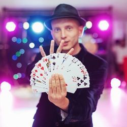 魔术师用一只手散布着粉丝形状的卡片甲板。