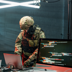 身穿迷彩服的士兵用笔记本电脑进行网络战。