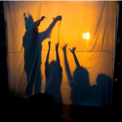 表演者窗帘上的影子和孩子们的手
