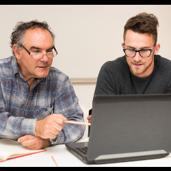 年长的男人和年轻的男人在看笔记本电脑