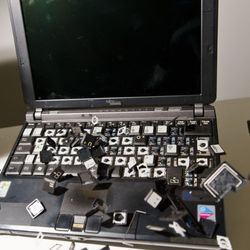 一台旧笔记本电脑的所有键都碎了，到处都是。