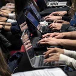 教室里，几个人的手在他们的笔记本电脑上打字。